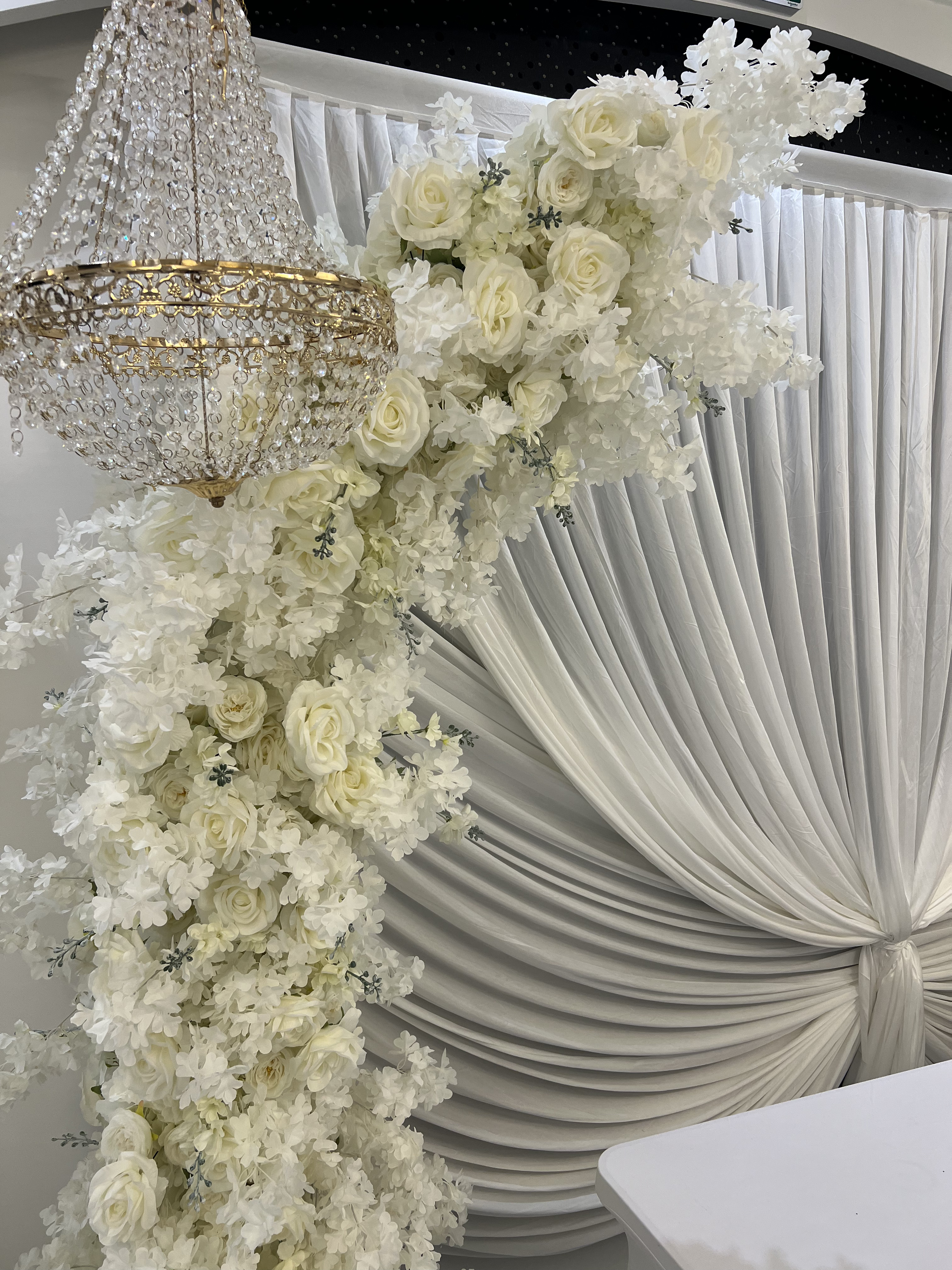 Cascade florale de roses blanches sur drapé d'honneur au Palace Victory Events
