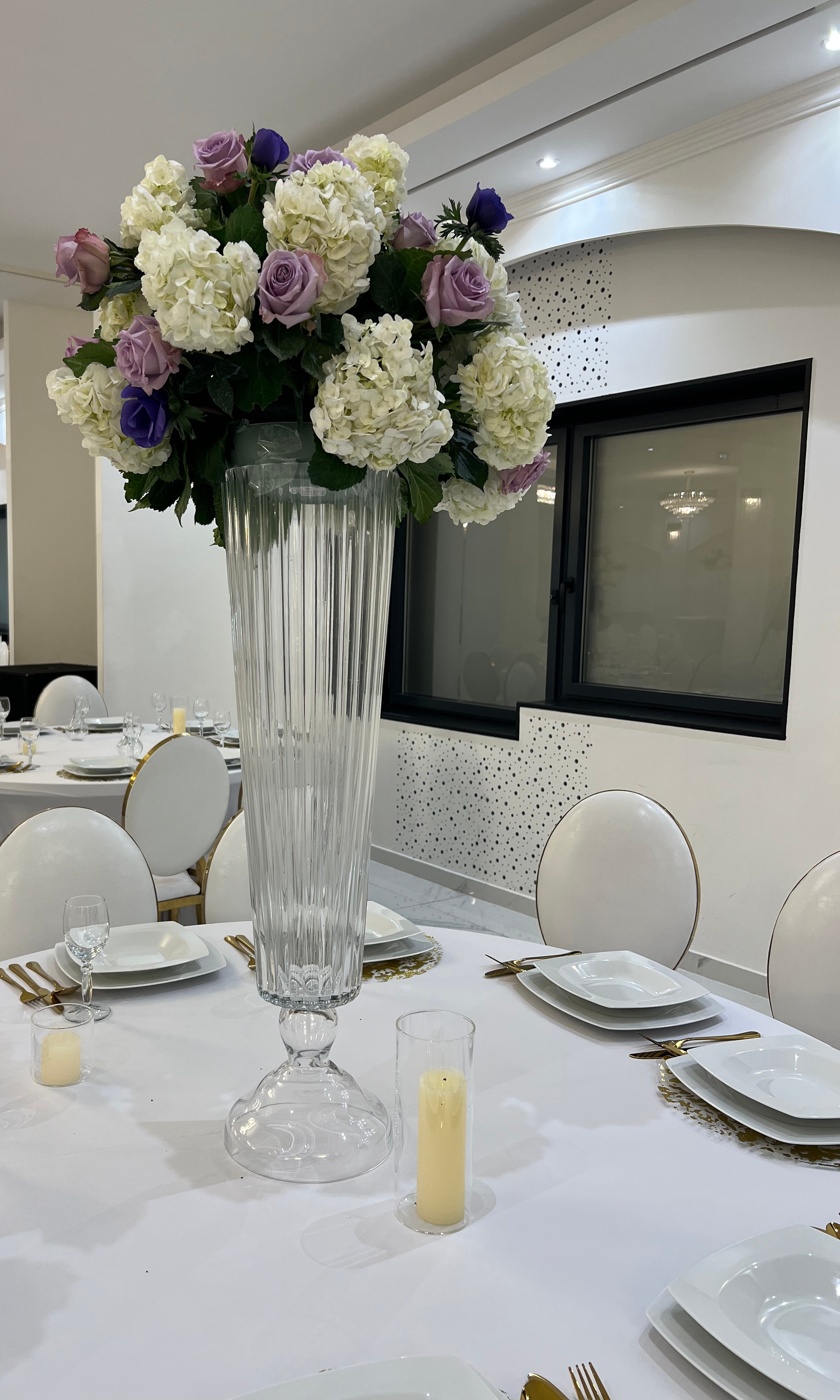 Centre de table en cristal avec hortensias et roses mauves sur table dressée au Palace Victory Events