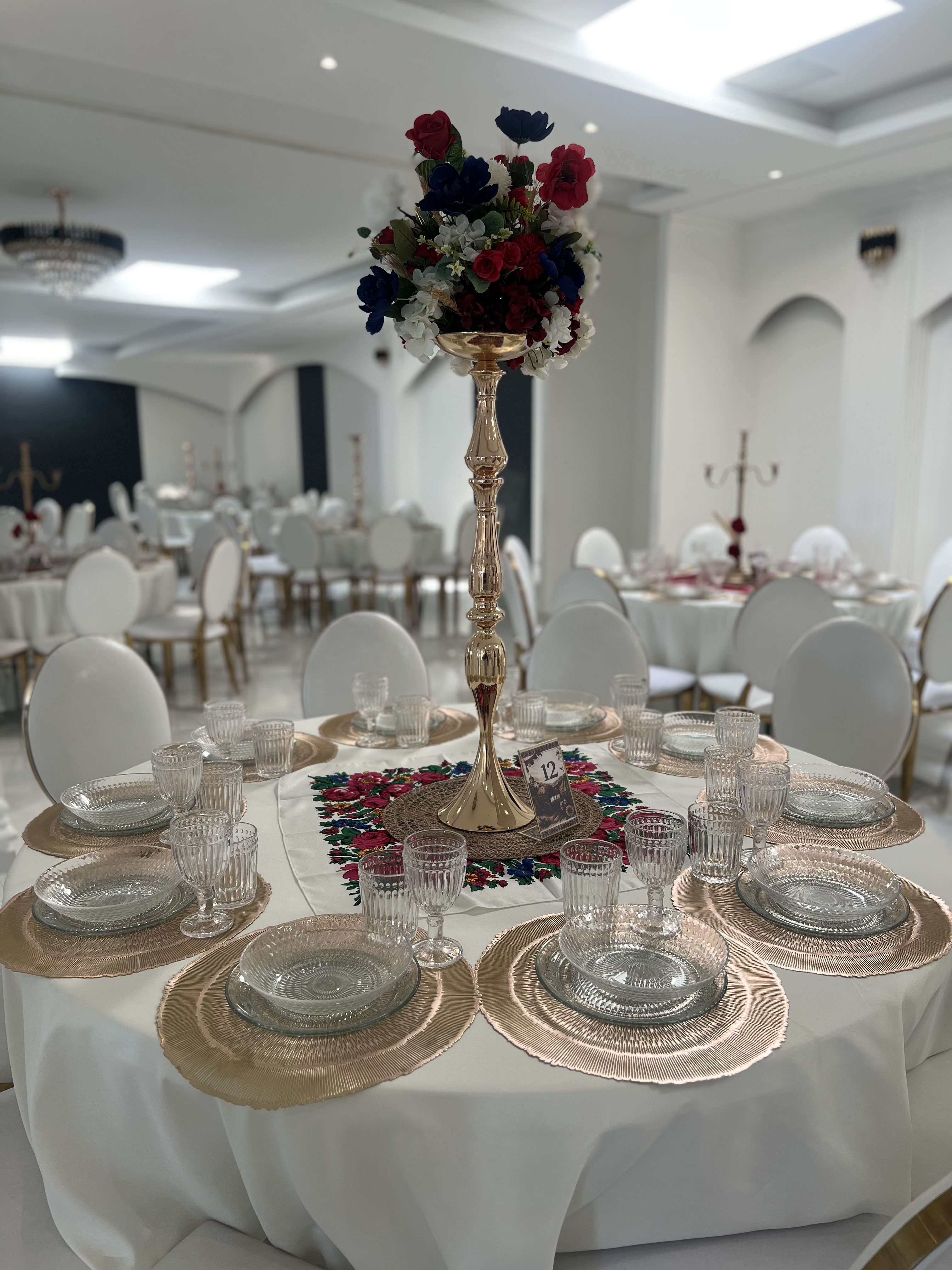 Table ronde du Palace Victory Events avec haut candélabre doré et composition florale colorée
